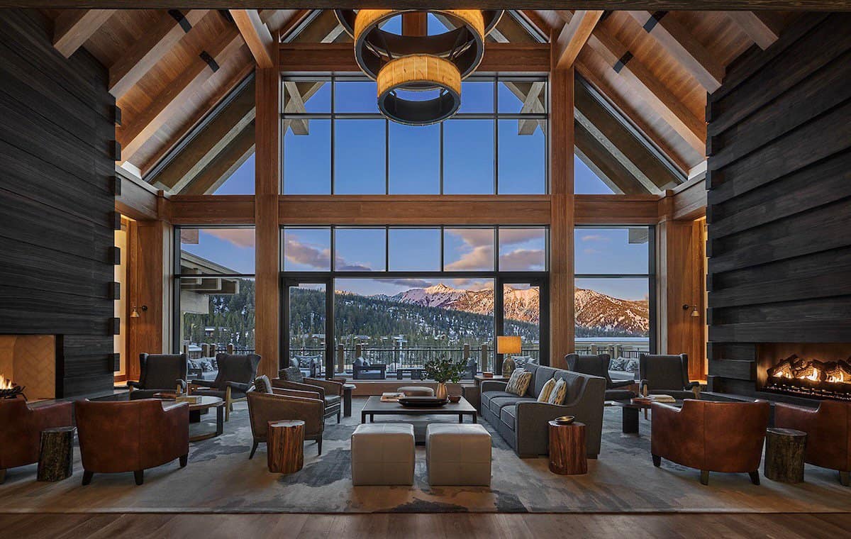 Spacious interior space with windowed walls and seating with mountains in the background
