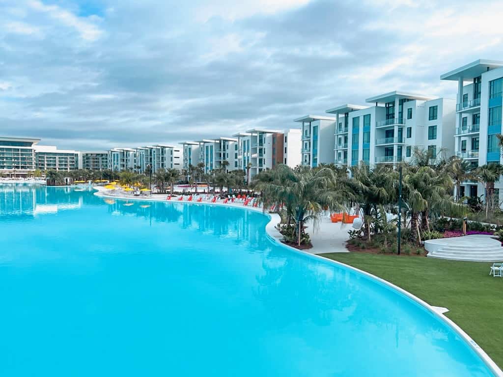 aerial view of a turquoise outdoor pool with backdrop of tall buildings at Evemore Orlando Resort