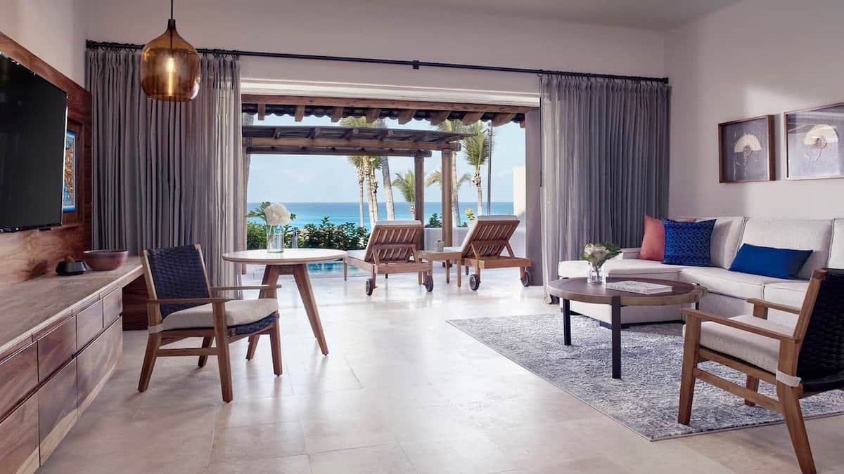 open living area with a couch and seating with outdoor space overlooking the ocean at Four Seasons Resort Punta Mita