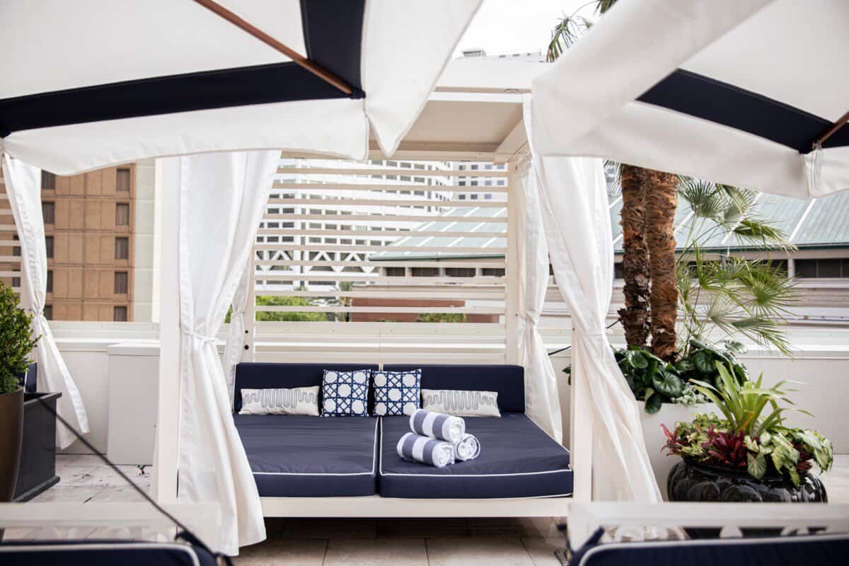daybed with blue and white decor at outdoor pool of The Windsor Court New Orleans