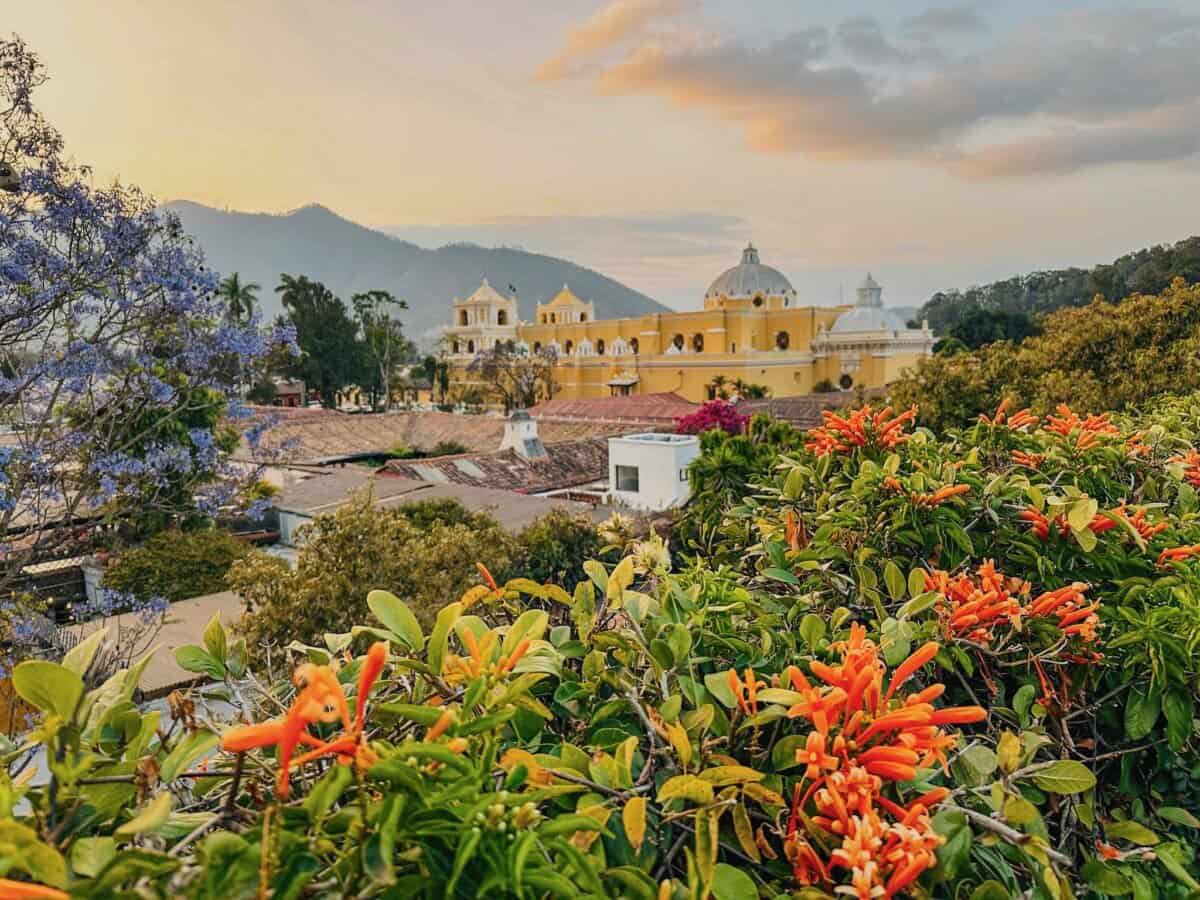 ornate yellow building with colorful flowers framing in Guatemala