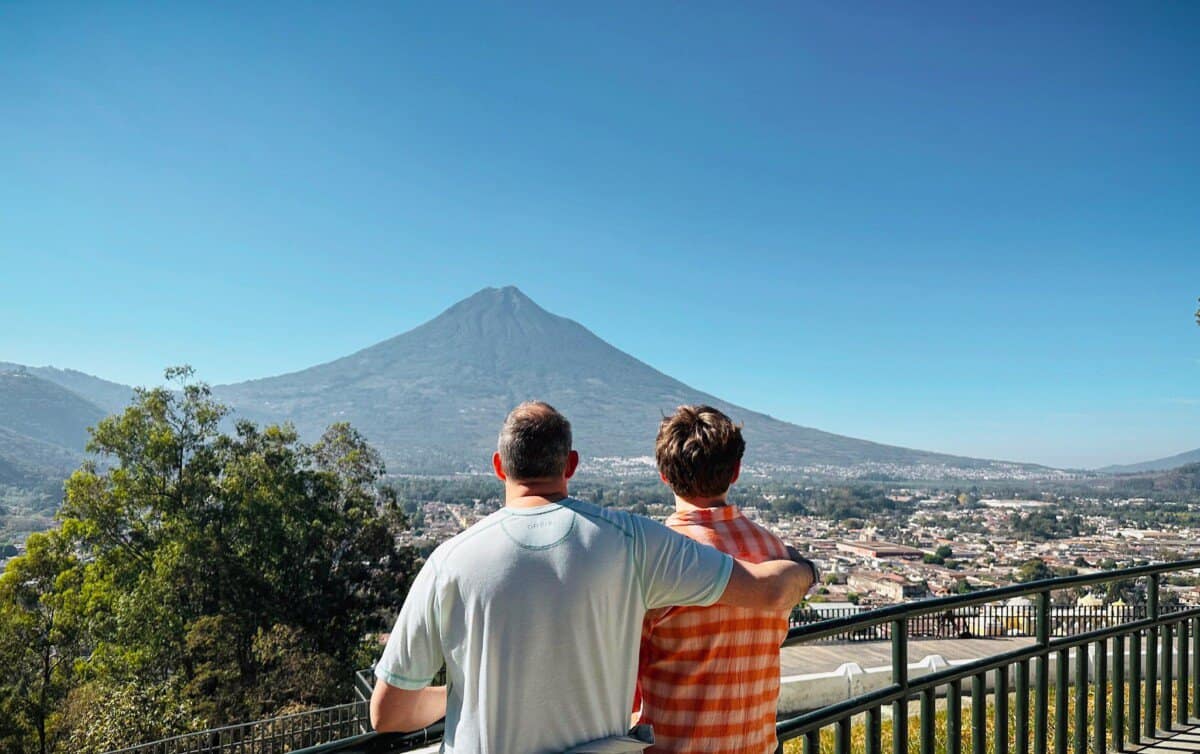 man and son embracing with large mountain in backdrop