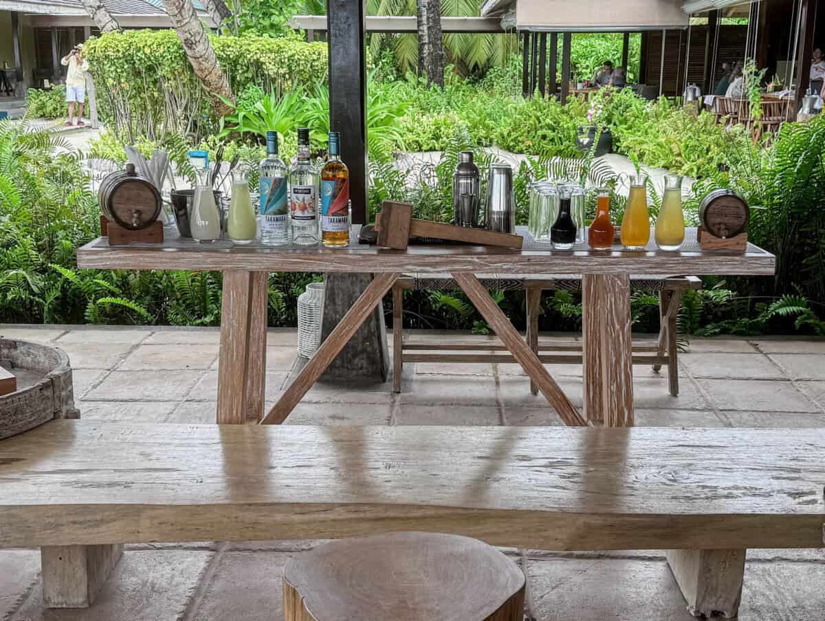 wood table with liquor bottles and bottles with juice