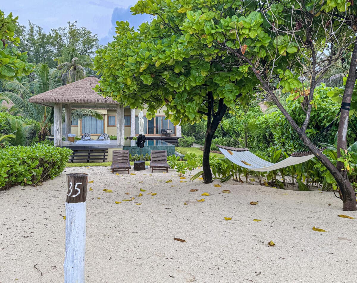 outdoor beach space with hammock and accommodation in backdrop at Four Seasons Seychelles Resorts