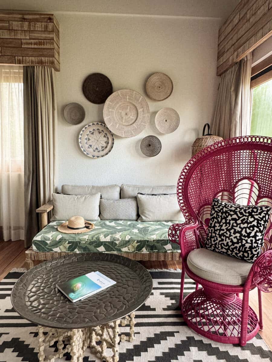 living area with decorative wall and red chair at Four Seasons Seychelles Resorts