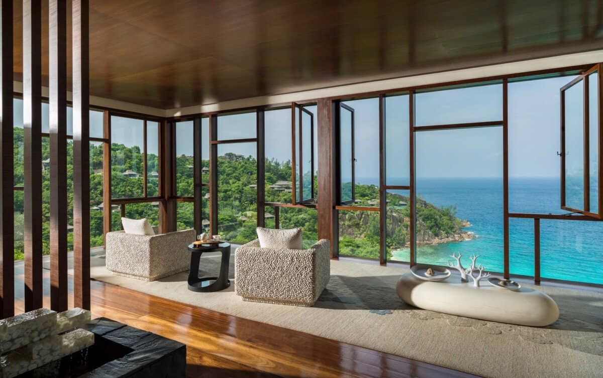 open living area with large glass windows overlooking the coastline at Four Seasons Seychelles Resorts