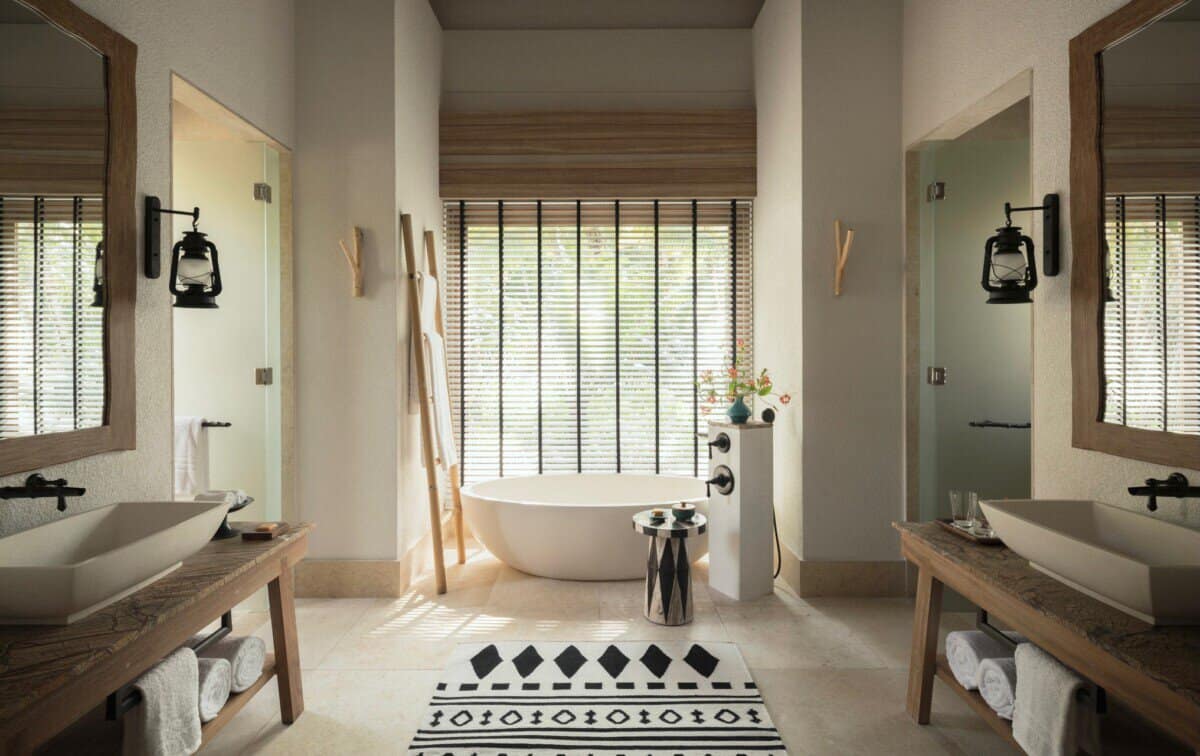 large bathroom with white and wood decor and soaking tub at Four Seasons Seychelles Resorts