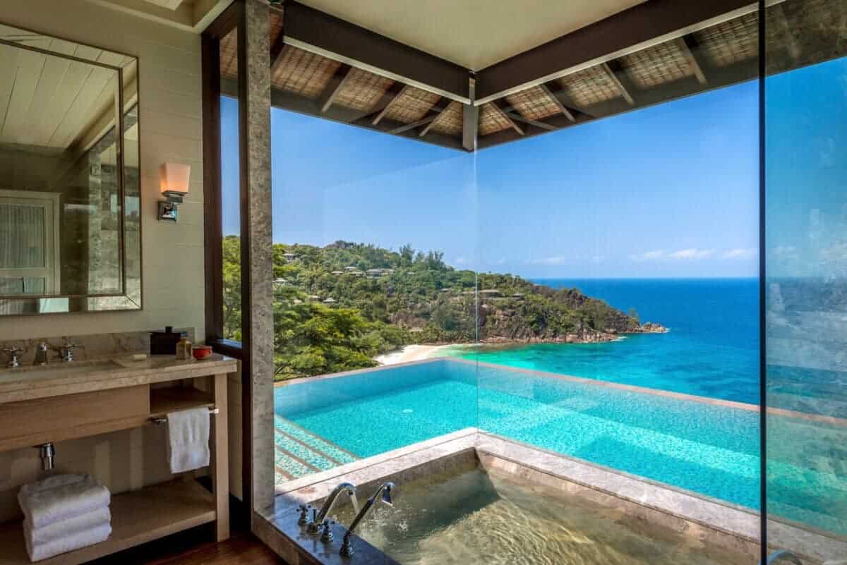 large glass windows with view of infinity pool overlooking the ocean at Four Seasons Seychelles Resorts