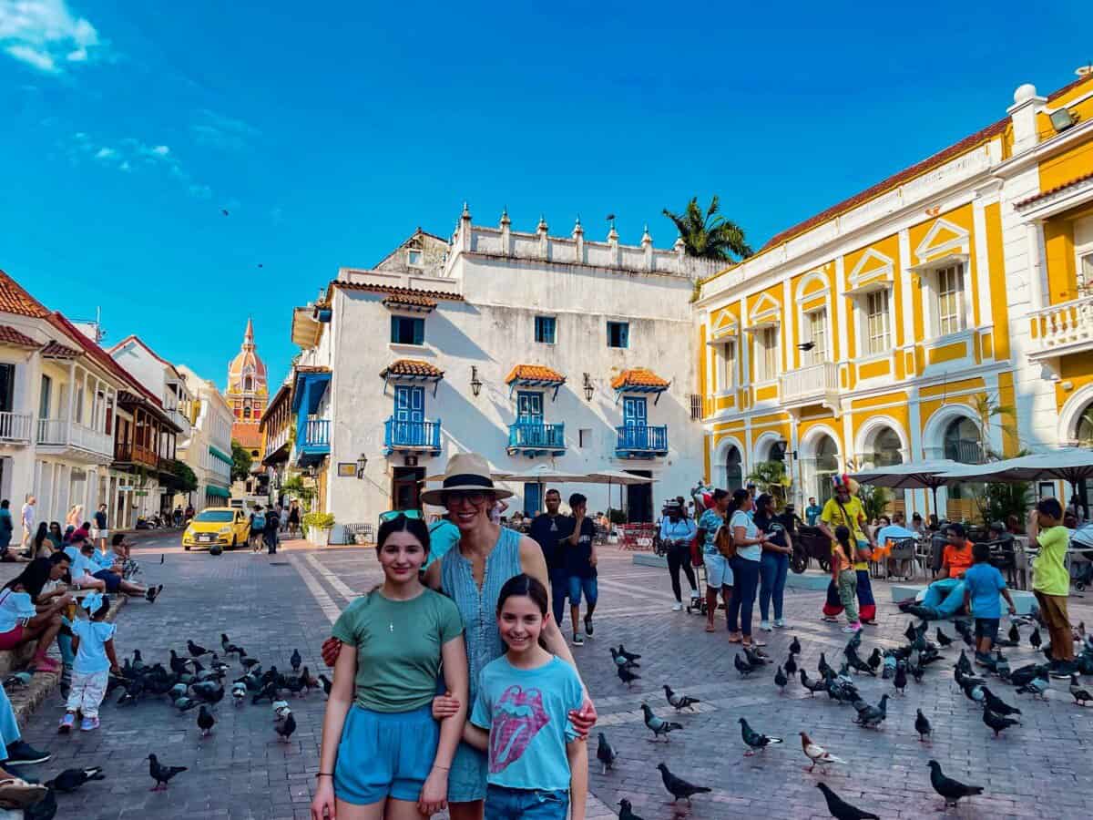 mother and two children posting in front of historic buildings in Cartagena, Colombia