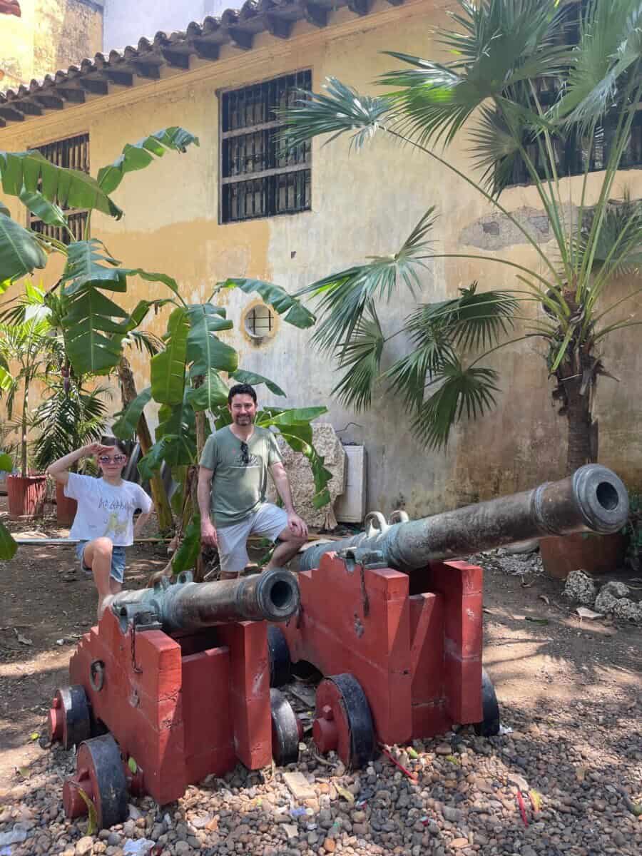 man and child posing in front of cannons and historic buildings in Cartagena, Colombia