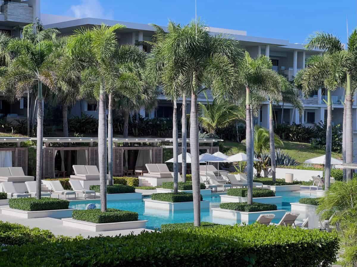 outdoor pool area with sun loungers and palm trees at Four Seasons Resort Anguilla