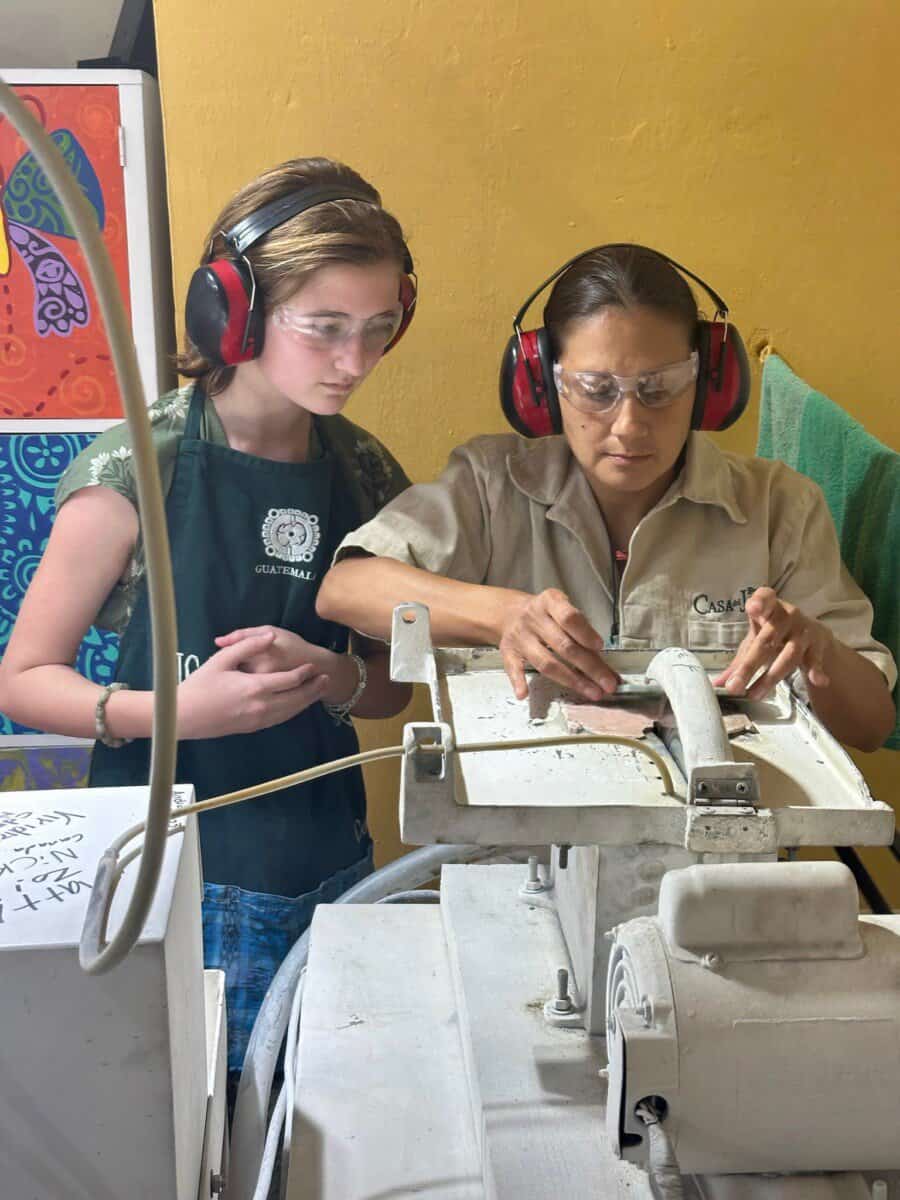 young girl watches a craftswoman in Guatemala