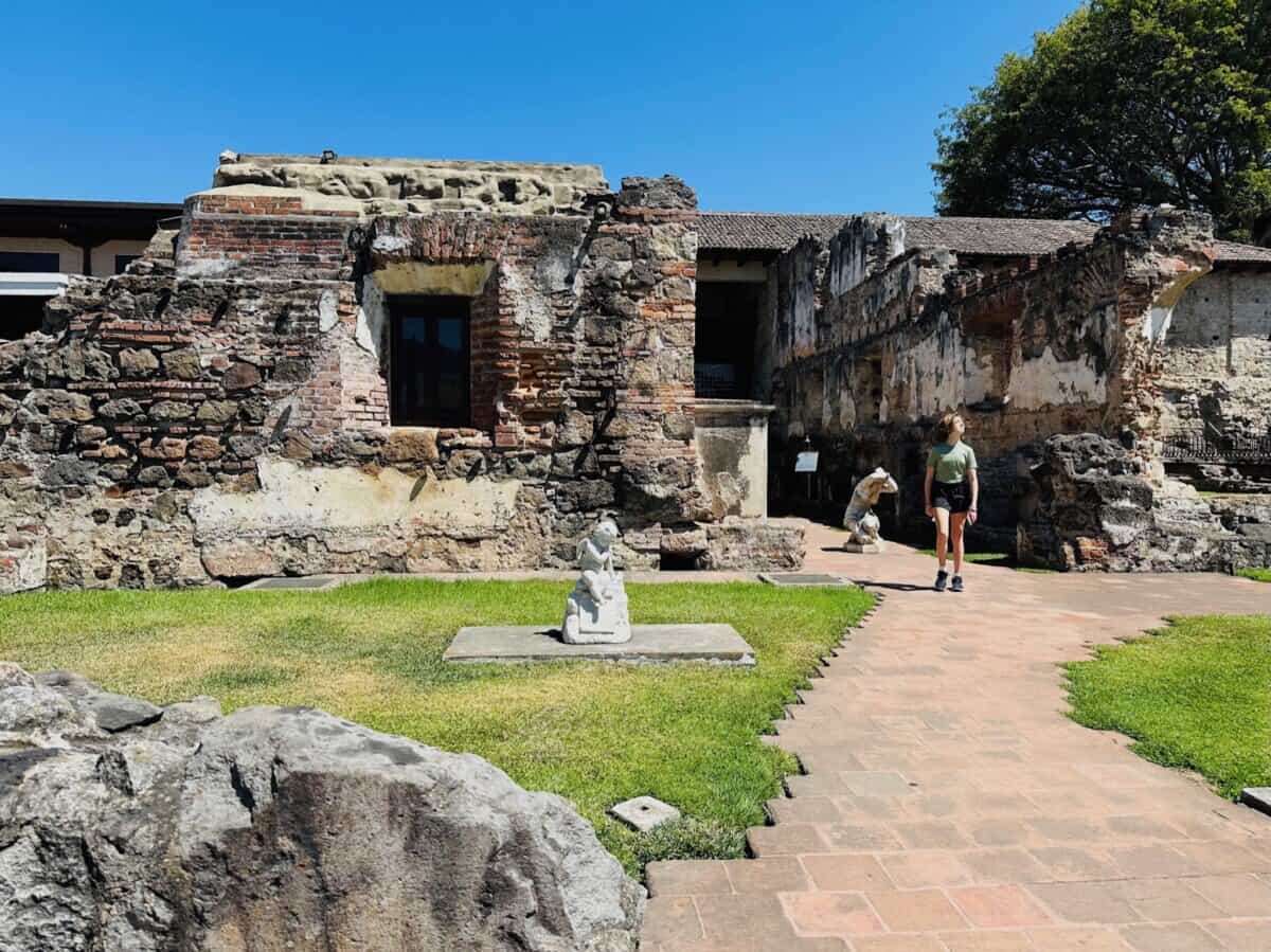 young woman walking through historic site and ancient ruins in Guatemala